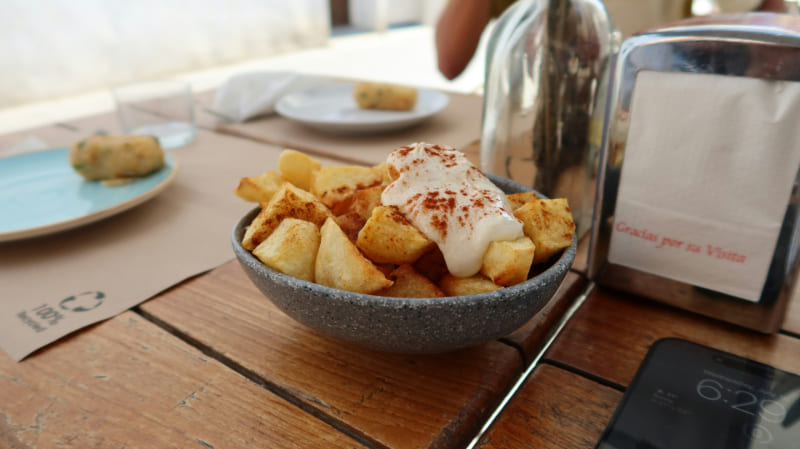 Patatas bravas doradas y crujientes con salsa brava casera y toque de alioli, una de las tapas más populares de la gastronomía española.